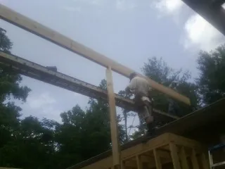 Carpenter setting a ridge beam over a new addition frame — Ice Dam Removal by Roofing Brothers in Knightsen